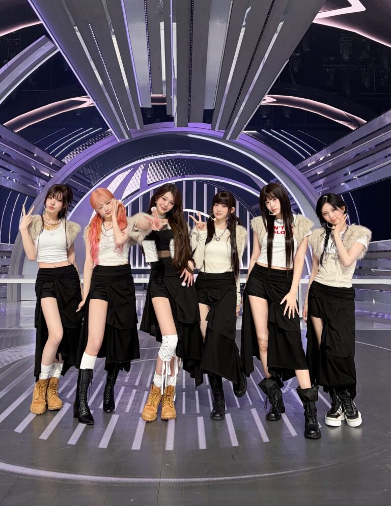 IVE members performing on a futuristic stage in coordinated black and white outfits.