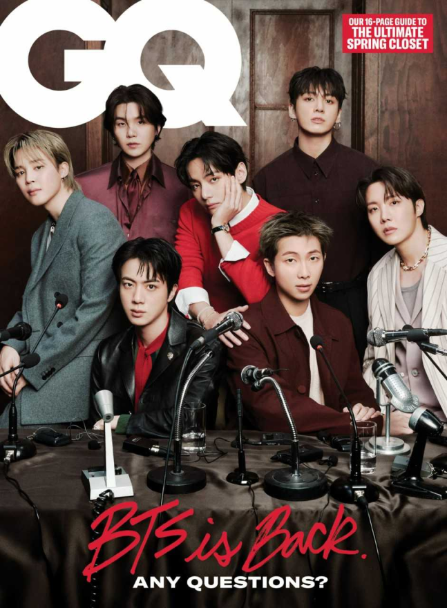 Cover of GQ magazine March issue featuring BTS. The members are dressed in coordinated, stylish outfits, posed at a press conference-style table with microphones, under the bold “GQ” logo. The headline reads “BTS is Back. ANY QUESTIONS?” highlighting their comeback.