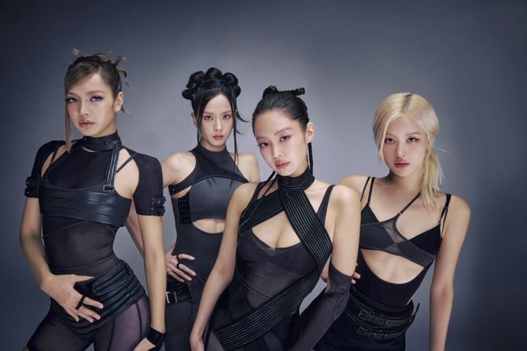 Four BLACKPINK members in futuristic black outfits posing confidently against a gradient background.