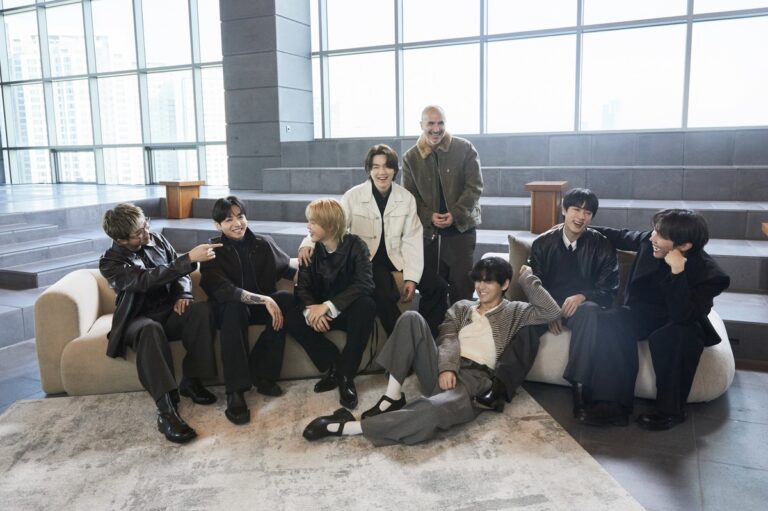 “BTS members during Apple Music interview at HYBE headquarters, seated together in a bright lounge.”