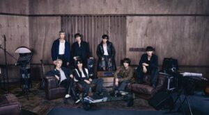 “BTS members posing in a music studio with instruments and recording equipment, highlighting creative atmosphere.”