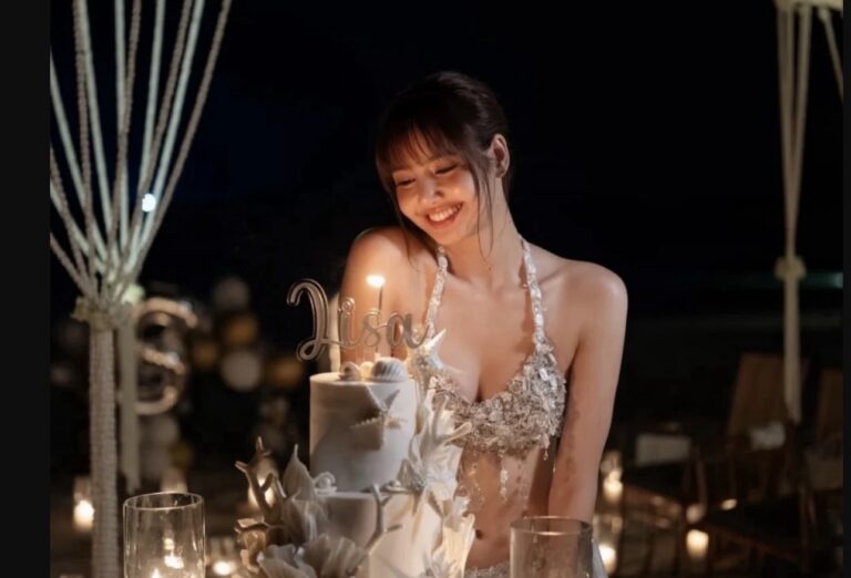 Lisa birthday celebration with decorated cake, candle, and name topper at an elegant outdoor party.