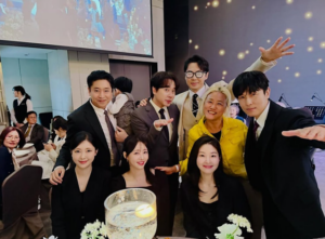 Shinhwa members and their wives get together to take a group photo at a wedding ceremony on March 29.
