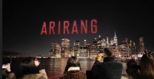 “BTS drone show above Brooklyn Bridge, spelling ARIRANG in red letters across the New York night sky.”