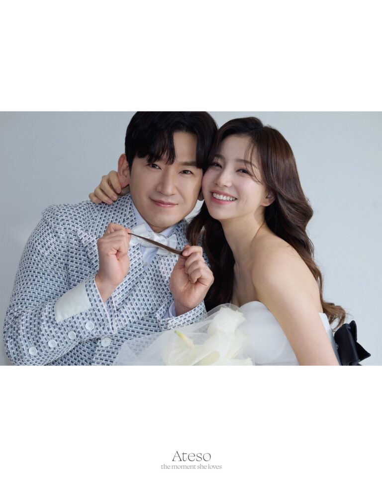 Couple in studio wedding portrait, Lee Min-woo in patterned suit playfully holding Lee Ami's hair, Ami in strapless white gown smiling. Caption: A joyful wedding moment captured in timeless elegance.