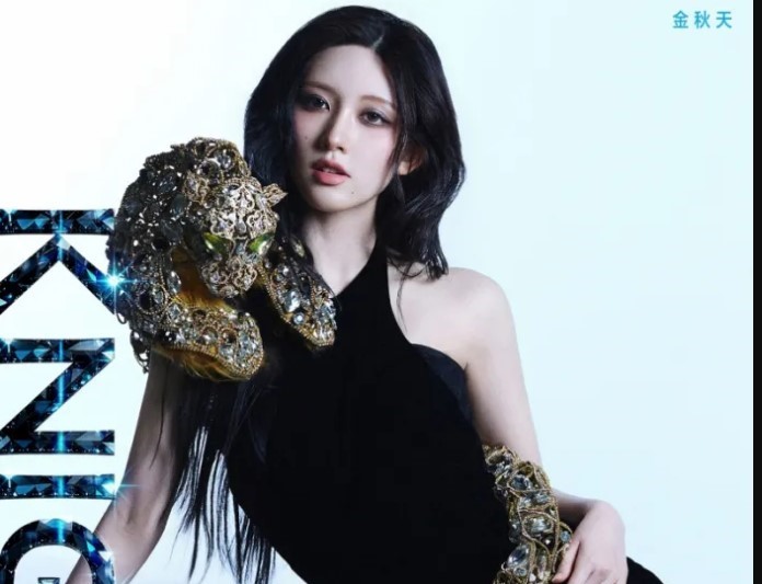 Gaeul poses in a black dress adorned with gold and jeweled leopard embellishments against a light background.