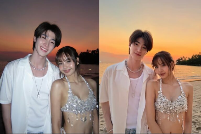 Lisa poses with Thai celebrity Blue Pongtiwat on a beach at sunset, smiling together in coordinated white outfits.