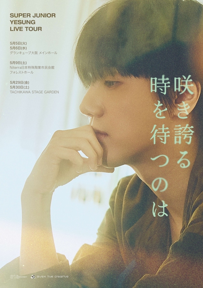 Close‑up portrait of Yesung with slightly red eyes and flushed cheeks under warm lighting.