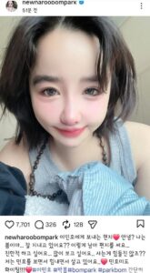 Park Bom takes a close-up selfie indoors, holding a striped pillow and wearing a gray sleeveless top.