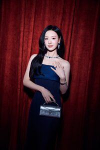 Actress Kim Ji-won poses elegantly in a navy strapless gown, holding a silver handbag and wearing BVLGARI jewelry at the brand’s “Eclettica” event in Seoul.