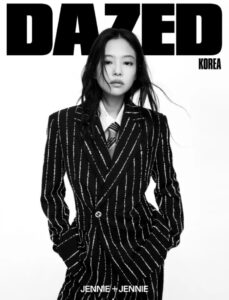 Jennie stands confidently in a pinstriped Chanel suit and tie on a black‑and‑white Dazed Korea cover.