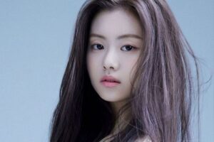 A close-up portrait of Kim Garam with long, softly tinted brown hair against a light blue background. Her expression is calm and natural, highlighting her youthful features.
