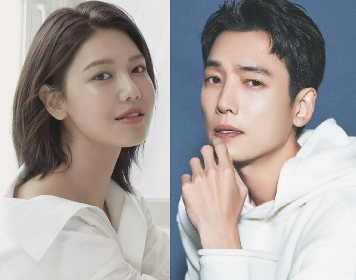 A side-by-side portrait of Girls’ Generation member Sooyoung and actor Jung Kyung-ho. Sooyoung, on the left, wears a white blouse and smiles softly against a bright background. Jung Kyung-ho, on the right, wears a white hoodie and poses with his hand near his chin against a blue backdrop.