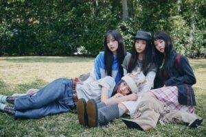 NewJeans members pose for a photo in their official homepage.