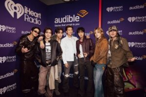 BTS members pose together in front of an iHeartRadio backdrop at the 2026 music festival